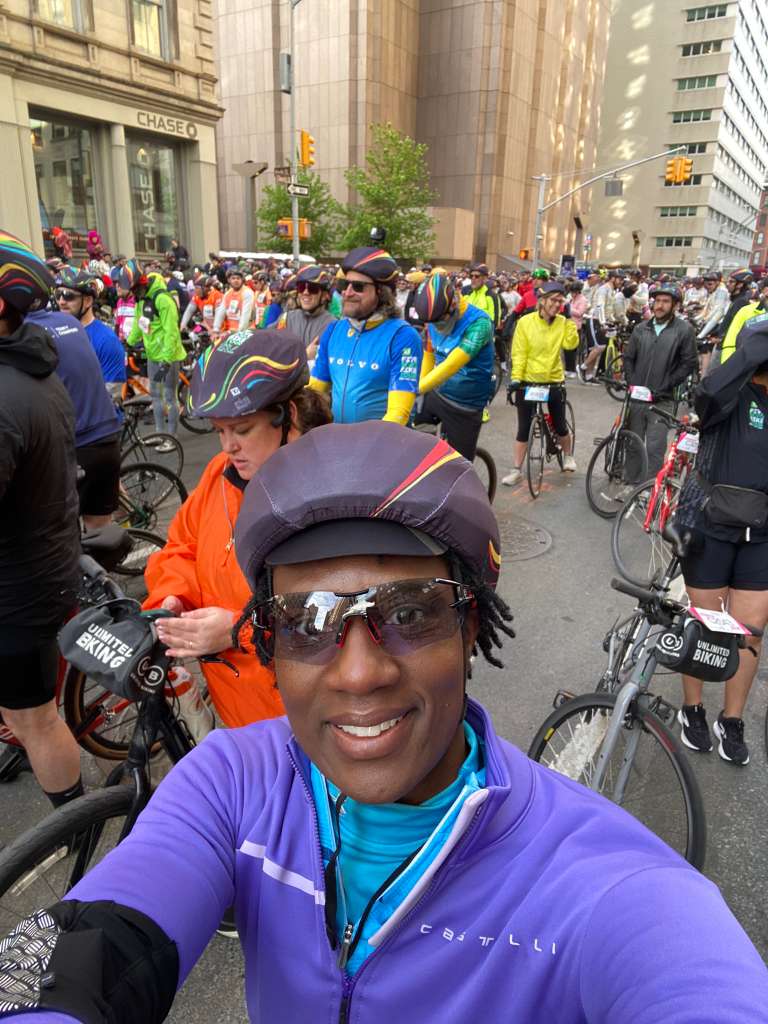 A Team C4C rider smiling in the pack of cyclists