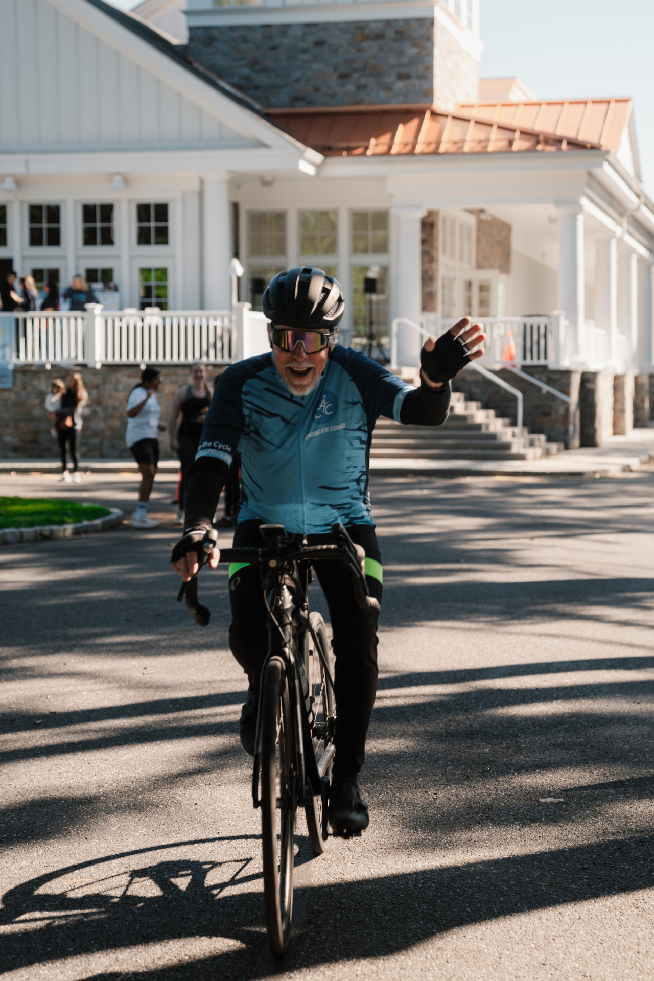 Cyclist waving while riding past the church