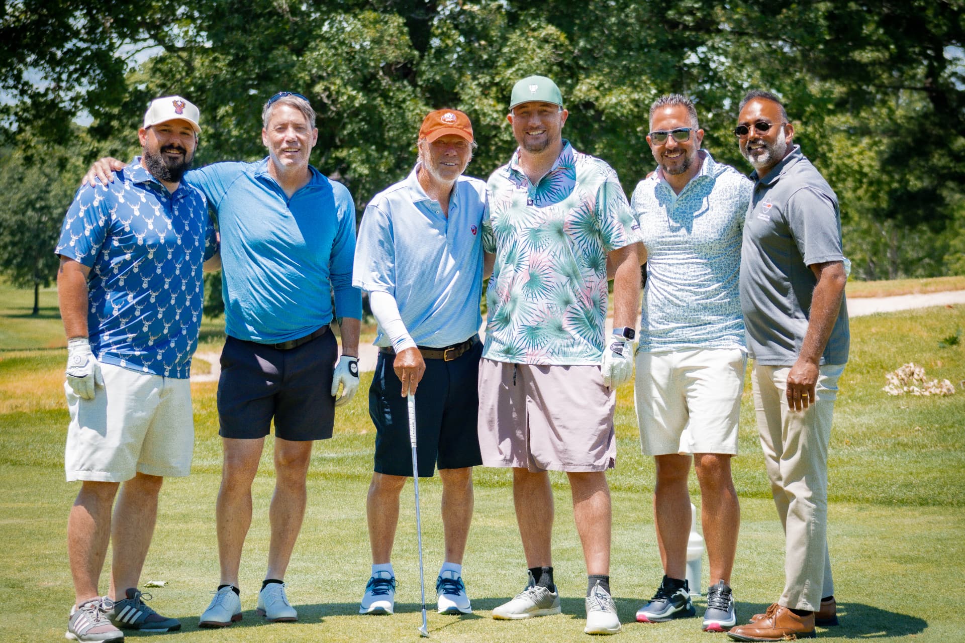 A foursome of golfers posing on the tee box