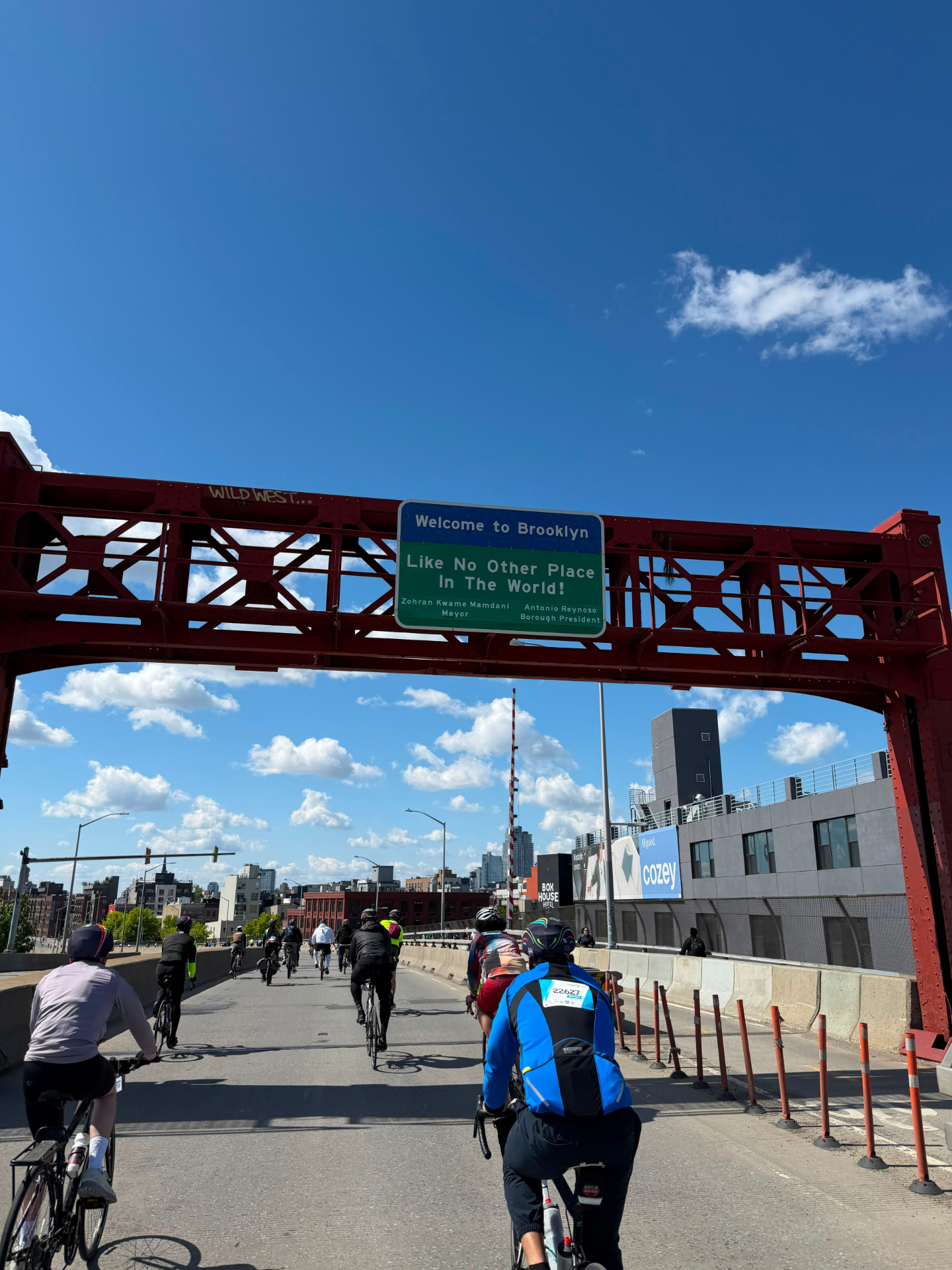 Riders passing the Welcome to Brooklyn sign during the tour