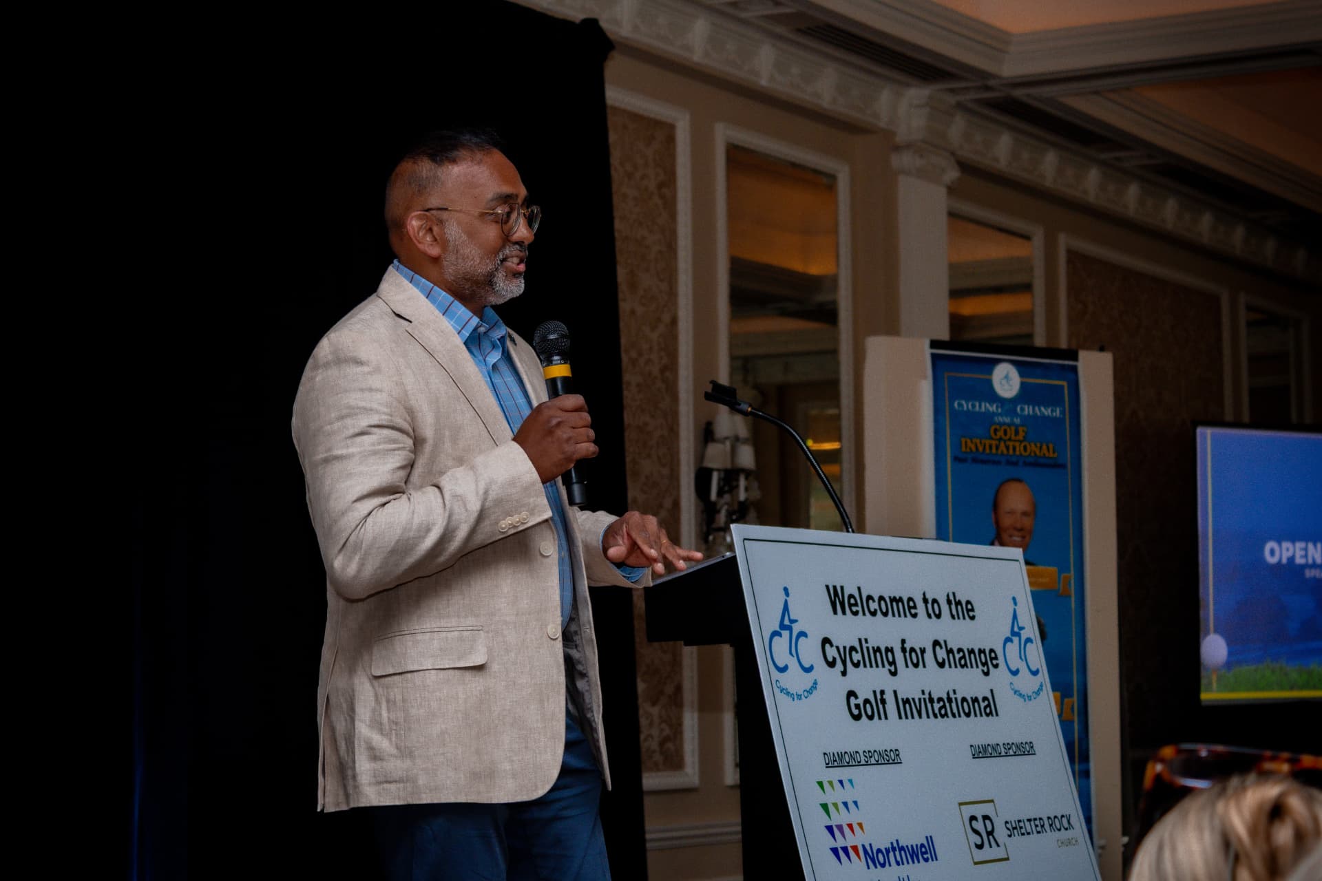 Host addressing guests at the Golf Invitational dinner