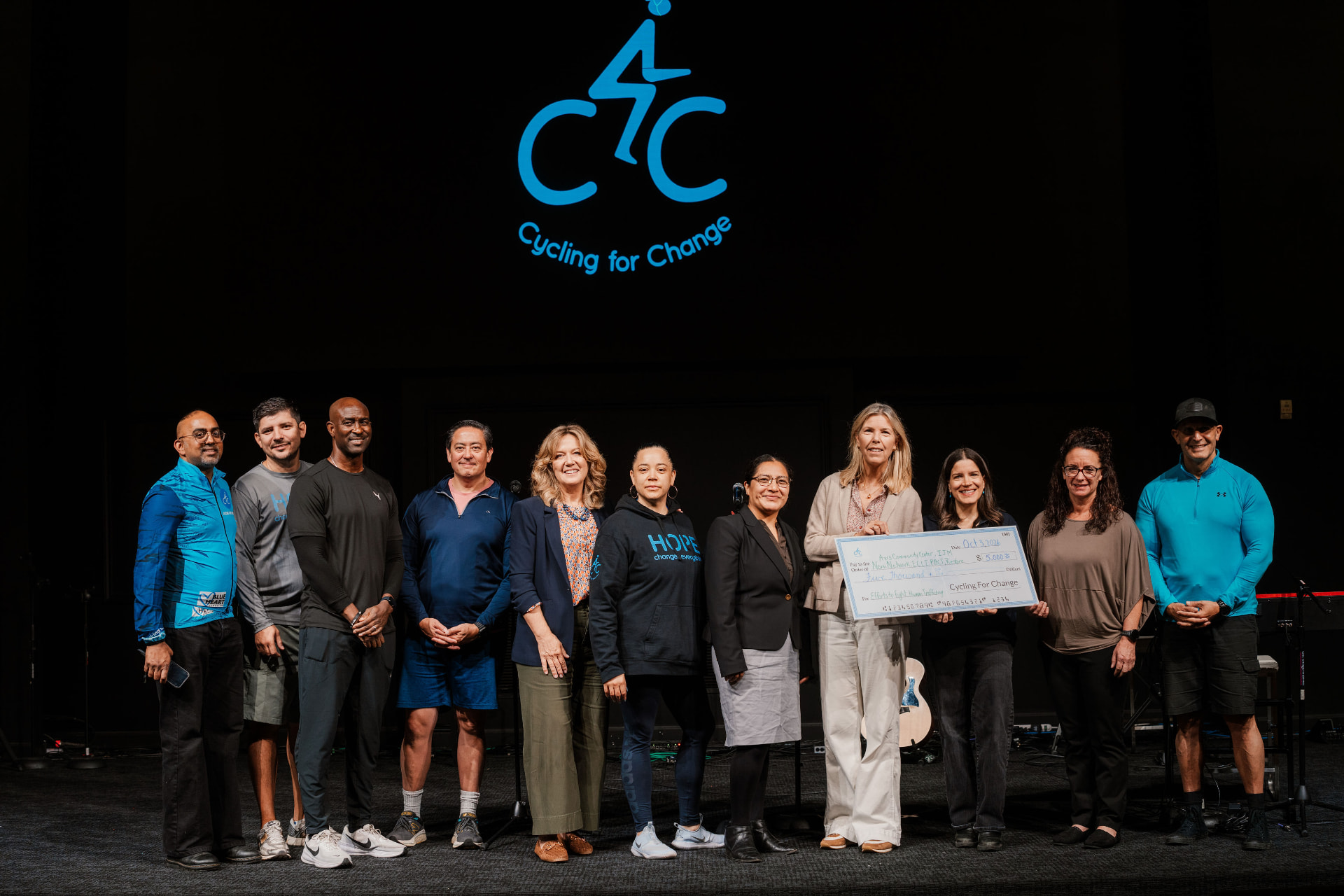 Team and partners presenting a donation check on stage at Hope Fest 2026