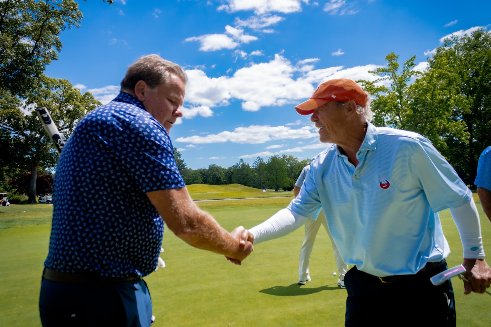 Two golfers shaking hands on the green